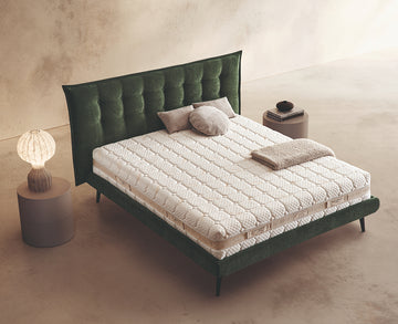 Materasso Befresh Air posizionato su un letto in ambiente neutro con sopra cuscini e scaldapiedi warmie