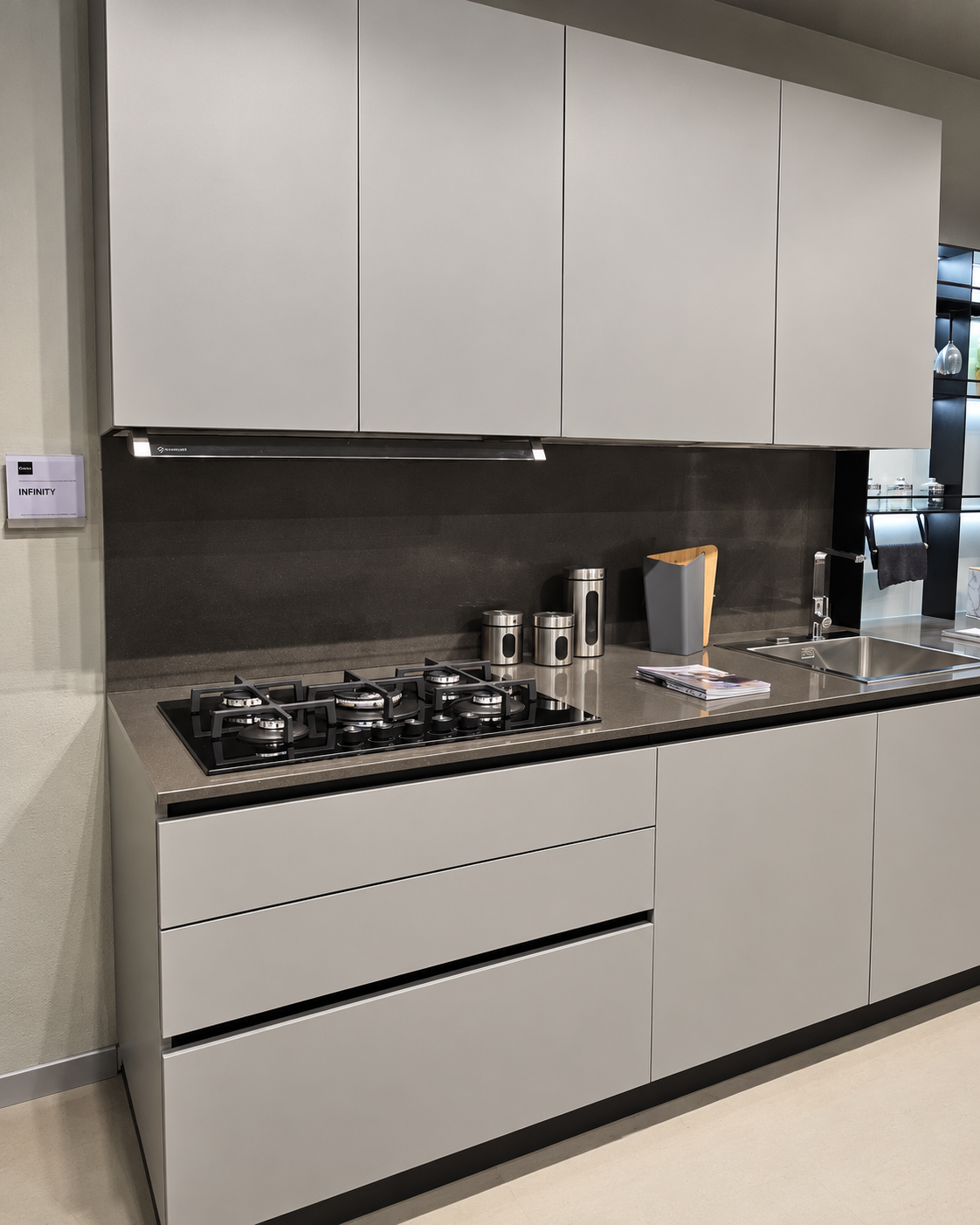 Zona cottura della cucina Stosa Infinity con basi a gola e piano in quarzo Cloudy Black